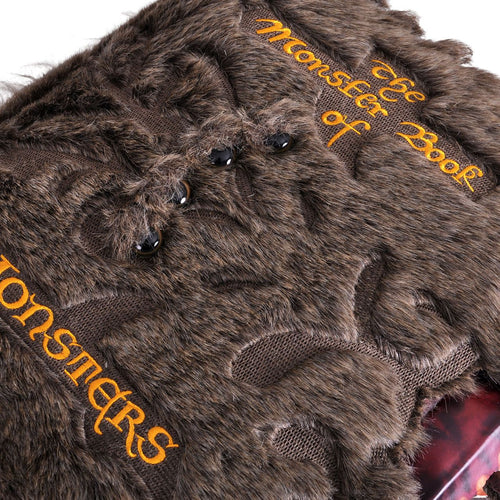 Dettaglio degli occhi e delle scritte ricamate del Libro dei Mostri di peluche